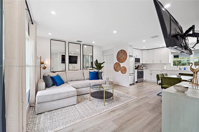 living room with sink and light hardwood / wood-style flooring