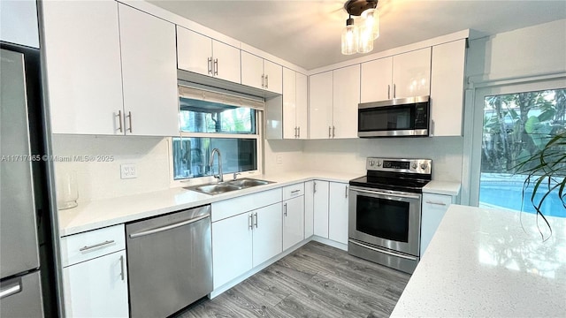 kitchen featuring white cabinets, light hardwood / wood-style floors, sink, and appliances with stainless steel finishes