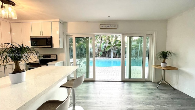 kitchen with white cabinetry, wood-type flooring, and appliances with stainless steel finishes