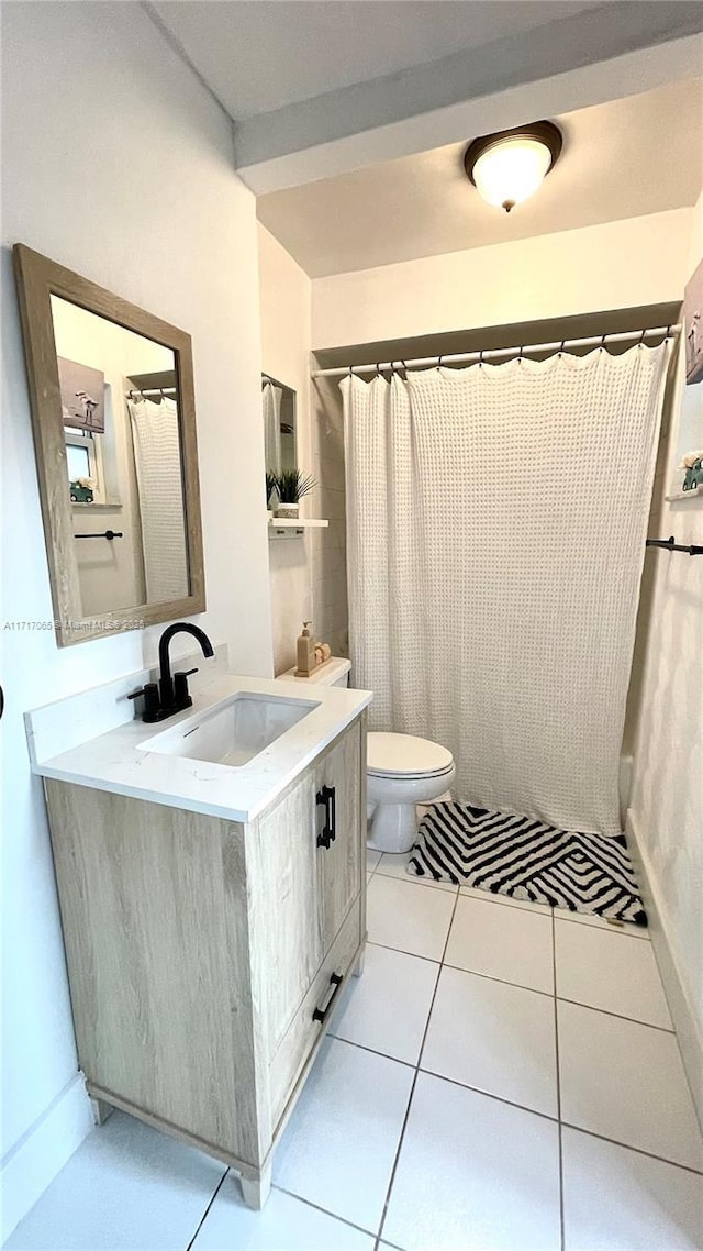 bathroom featuring tile patterned flooring, vanity, toilet, and walk in shower