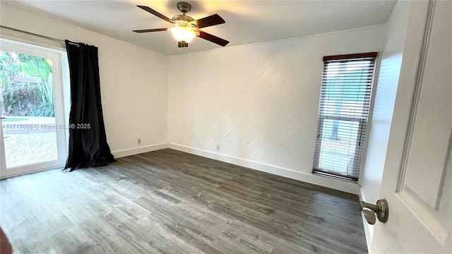 unfurnished room with a wealth of natural light, ceiling fan, and dark wood-type flooring