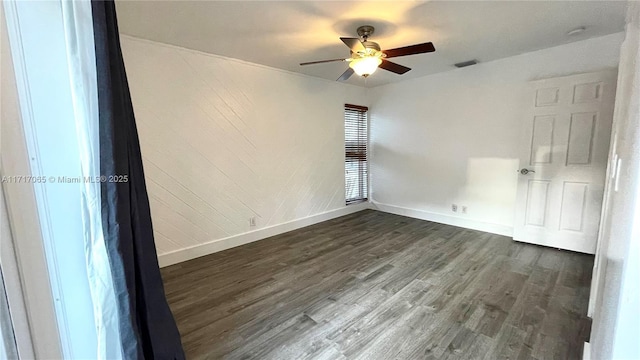 empty room with ceiling fan and dark wood-type flooring