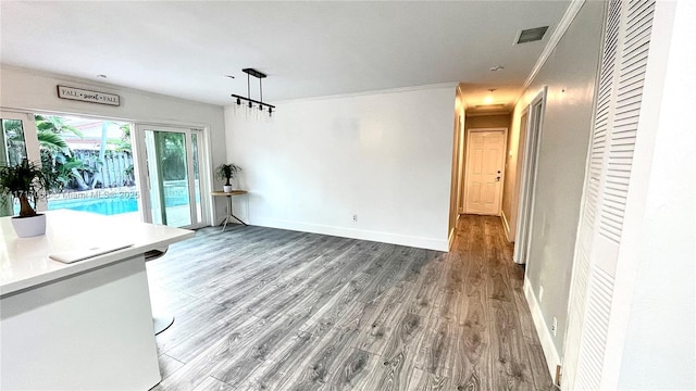 unfurnished living room with hardwood / wood-style floors and ornamental molding