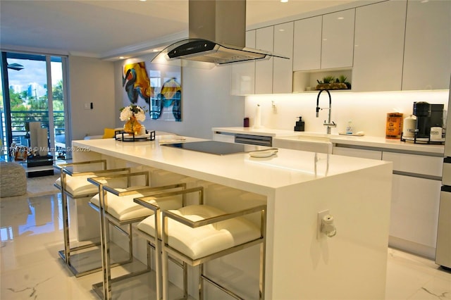 kitchen with island exhaust hood, a breakfast bar, sink, white cabinets, and a center island