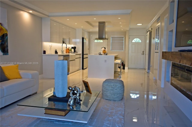 living room featuring sink and crown molding