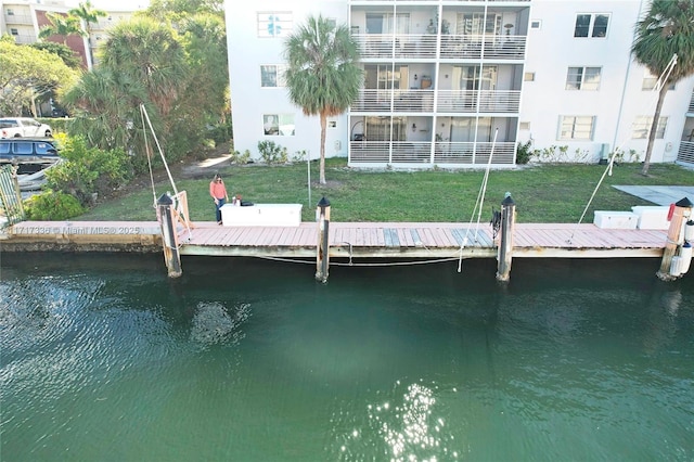 dock area with a water view and a lawn