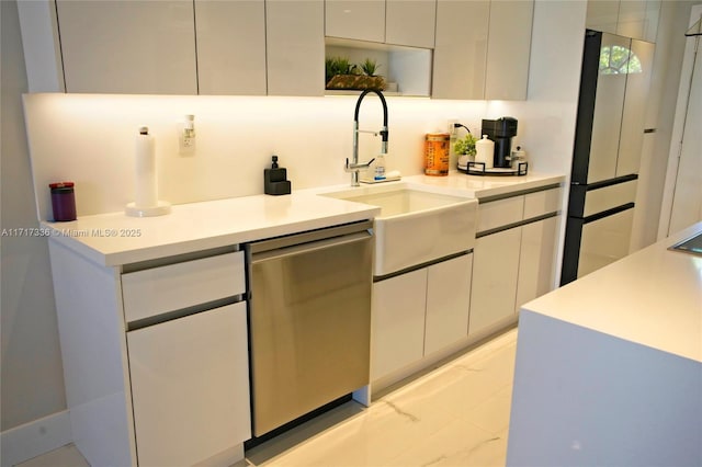 kitchen with sink, white cabinets, stainless steel dishwasher, and fridge