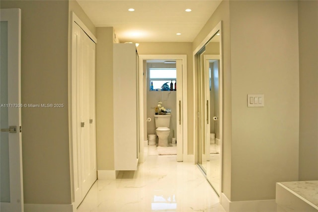 hall featuring baseboards, marble finish floor, and recessed lighting