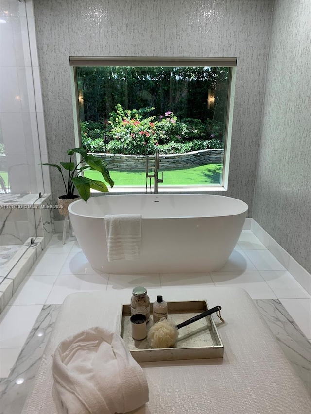 bathroom featuring a tub to relax in and plenty of natural light