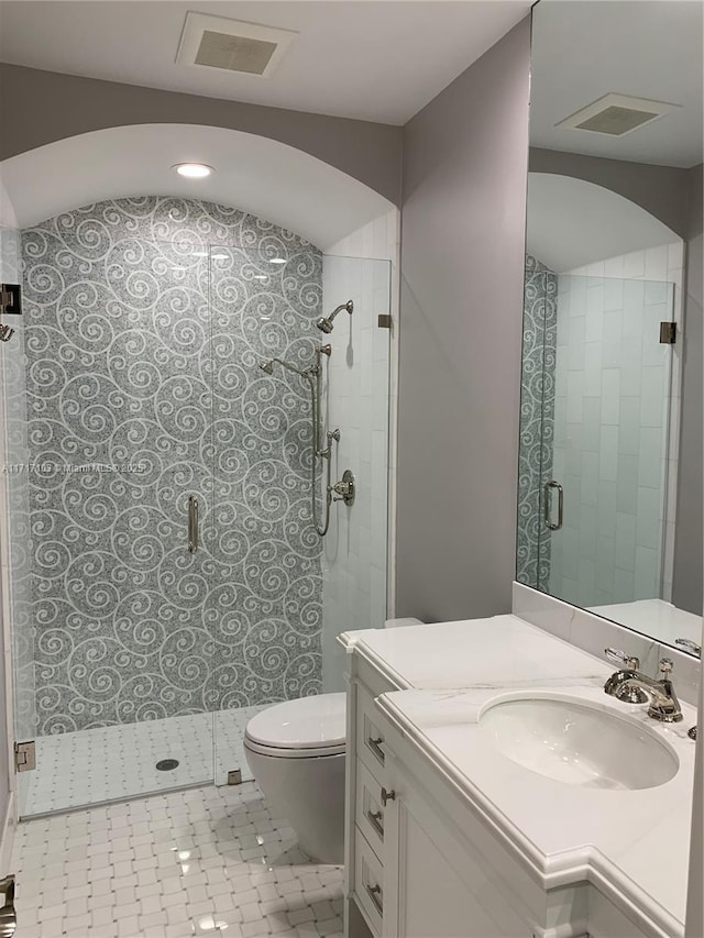 bathroom featuring walk in shower, vanity, and toilet