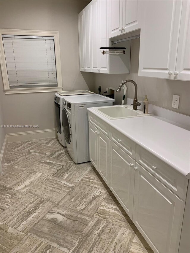 washroom featuring separate washer and dryer, sink, and cabinets