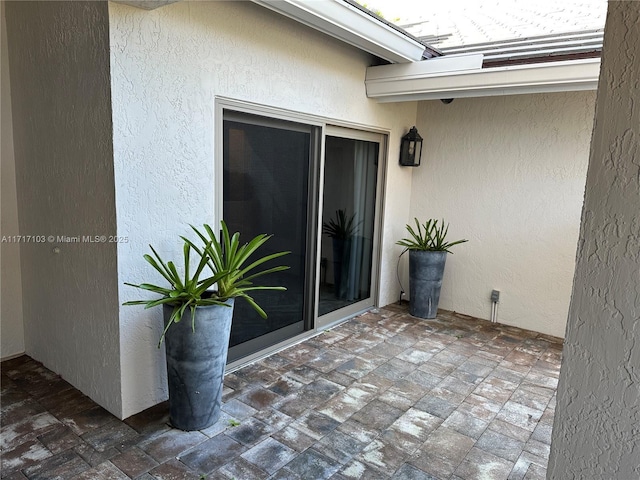 view of exterior entry with a patio