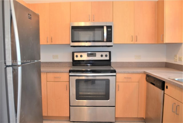 kitchen featuring stainless steel appliances and light brown cabinetry