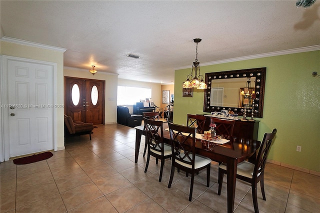 dining room featuring tile patterned flooring, a textured ceiling, crown molding, and an inviting chandelier