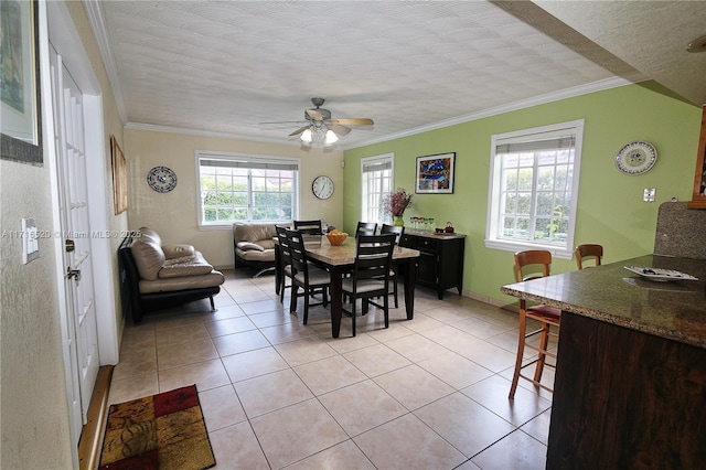 dining space featuring ceiling fan, light tile patterned floors, a textured ceiling, and ornamental molding