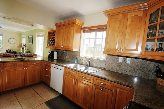 kitchen with dishwasher, sink, decorative backsplash, light tile patterned floors, and kitchen peninsula