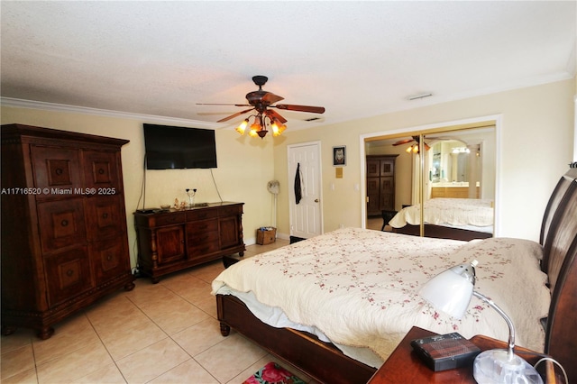 tiled bedroom featuring connected bathroom, ceiling fan, a textured ceiling, and ornamental molding