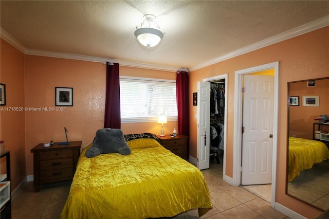 tiled bedroom with a spacious closet, crown molding, and a closet