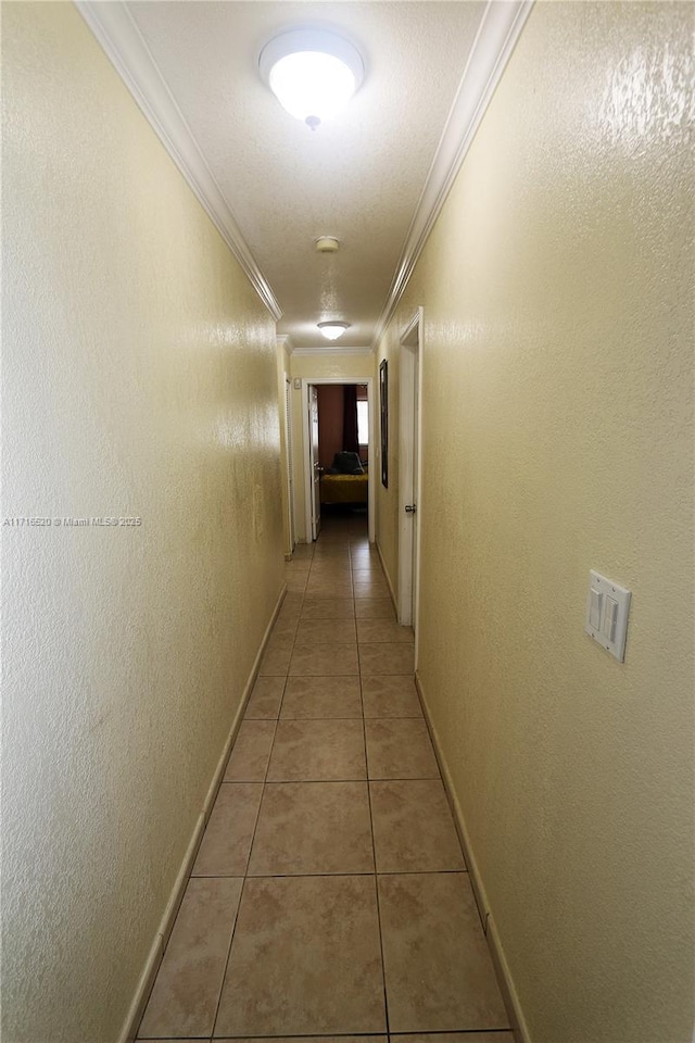 hall featuring tile patterned flooring, a textured ceiling, and ornamental molding