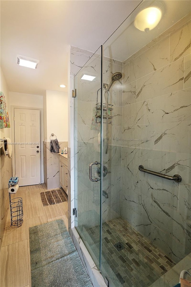 bathroom with vanity and a shower with door