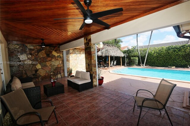 view of swimming pool with an outdoor living space, ceiling fan, and a patio area