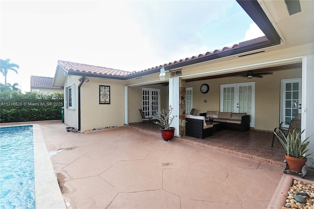 back of property with outdoor lounge area, french doors, ceiling fan, and a patio area