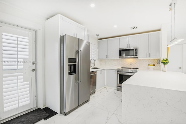2550 SW 68th Ave, Miami, FL 33155 - kitchen featuring appliances with stainless steel finishes, a breakfast bar, white cabinets, backsplash, and hanging light fixtures