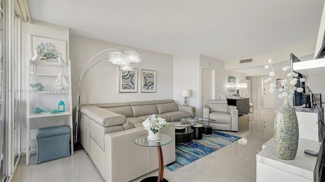 tiled living room with a notable chandelier