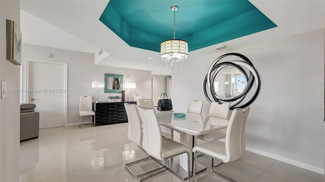 tiled dining room featuring a raised ceiling