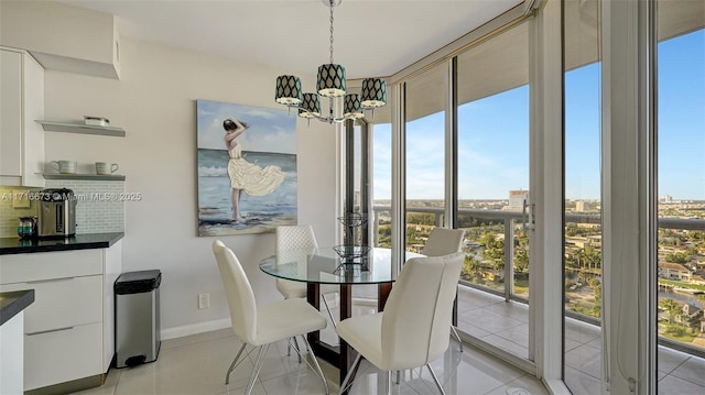 tiled dining area featuring a healthy amount of sunlight and a chandelier