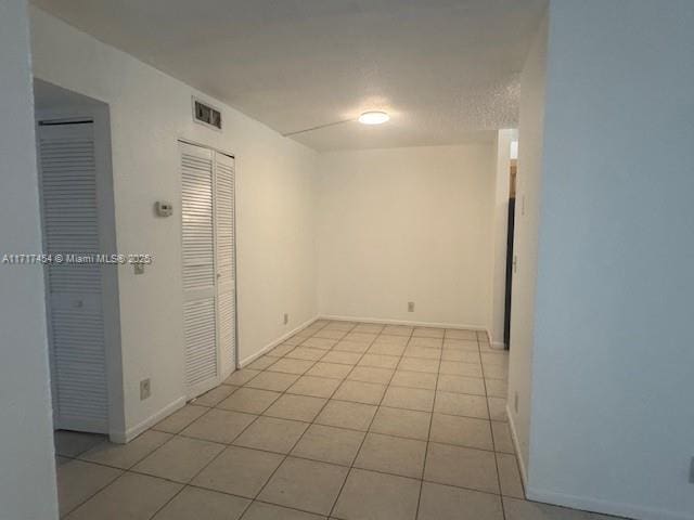 unfurnished room with light tile patterned floors and a textured ceiling