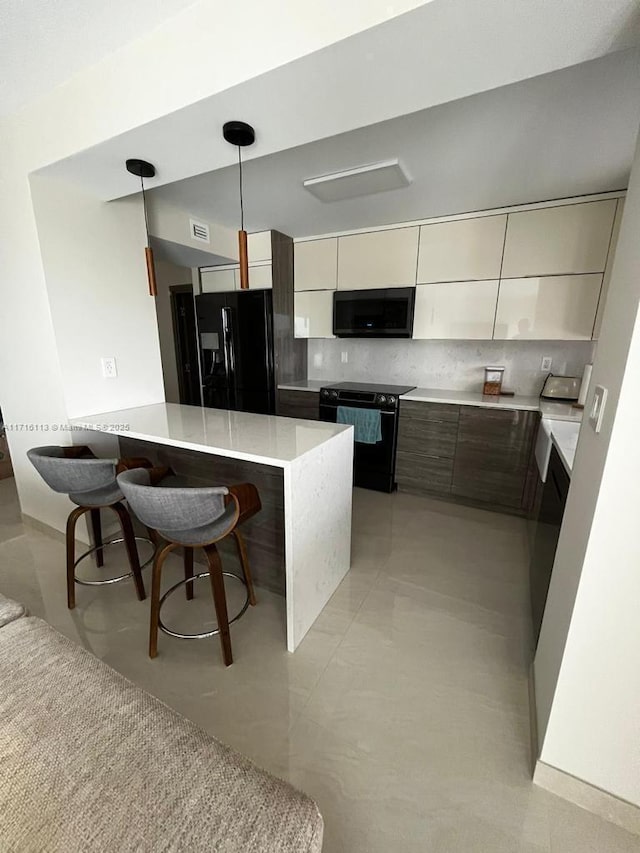 kitchen featuring a breakfast bar, backsplash, black appliances, hanging light fixtures, and kitchen peninsula