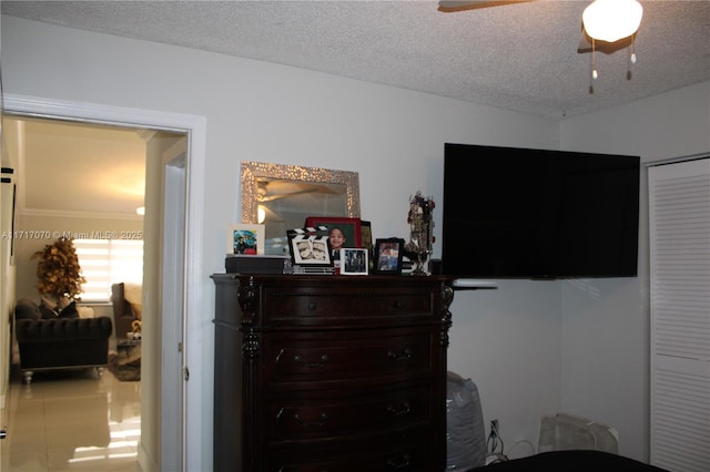 bedroom with ceiling fan and a textured ceiling