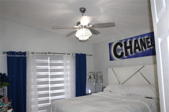 bedroom with ceiling fan and a textured ceiling