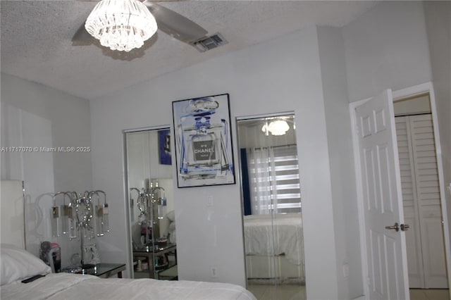 unfurnished bedroom featuring ceiling fan with notable chandelier and a textured ceiling