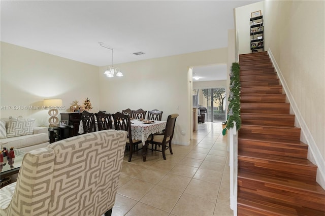 dining space featuring light tile patterned floors and an inviting chandelier