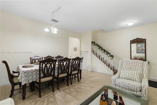 tiled dining room with a chandelier