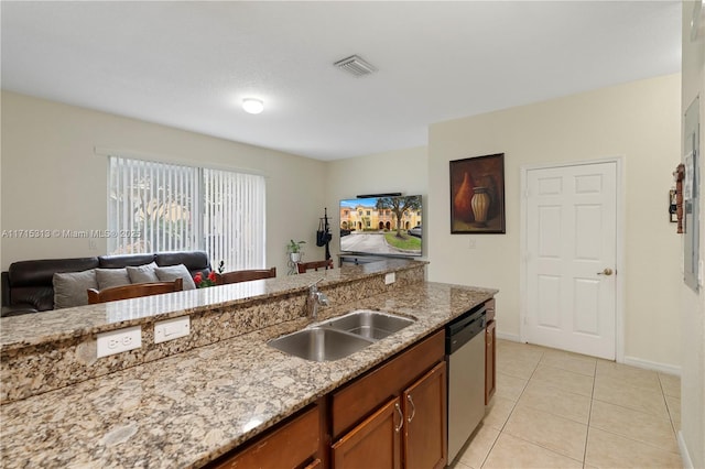 kitchen with stainless steel dishwasher, light tile patterned flooring, light stone countertops, and sink