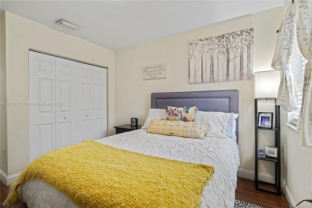 bedroom with dark wood-type flooring and a closet