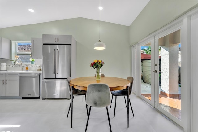 dining area featuring sink, a healthy amount of sunlight, and lofted ceiling