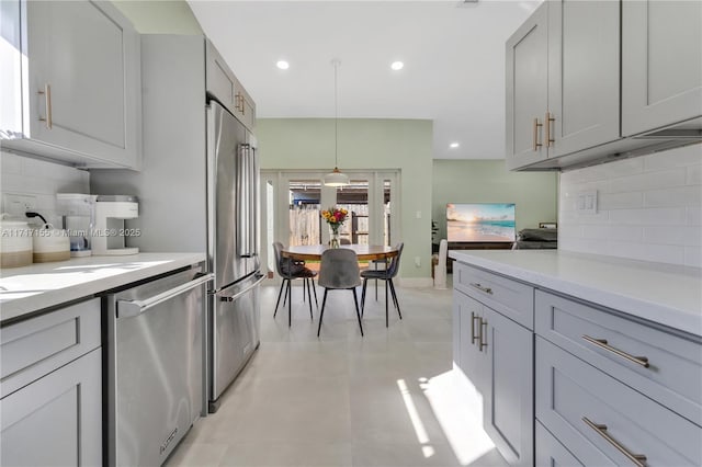 kitchen featuring hanging light fixtures, stainless steel appliances, tasteful backsplash, and gray cabinetry