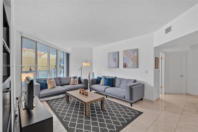 tiled living room featuring floor to ceiling windows and a textured ceiling