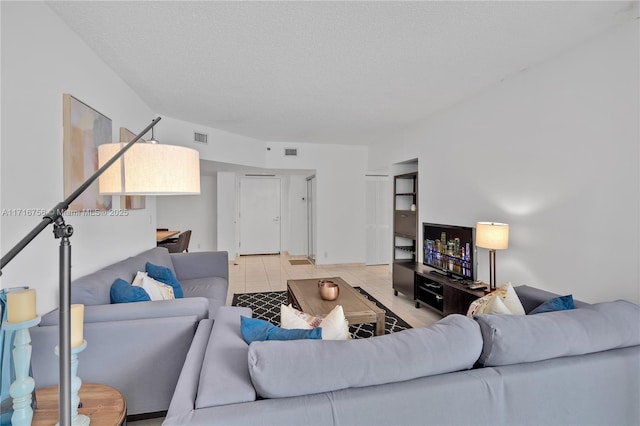 tiled living room featuring a textured ceiling