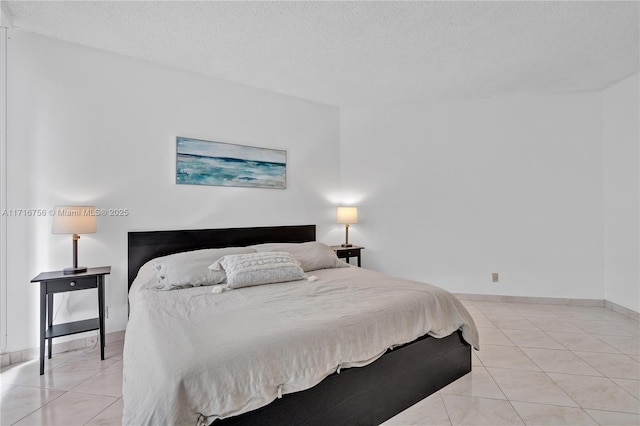 bedroom with light tile patterned floors and a textured ceiling