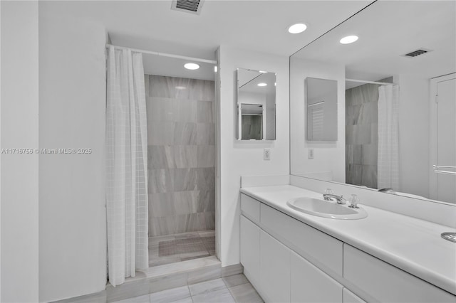 bathroom featuring tile patterned flooring, vanity, and walk in shower