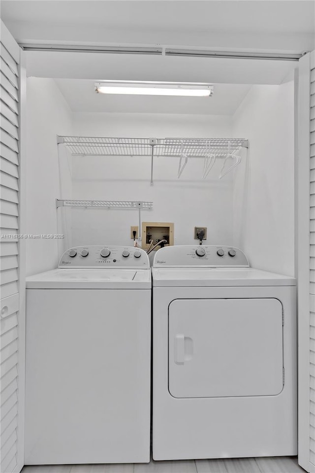 clothes washing area with separate washer and dryer