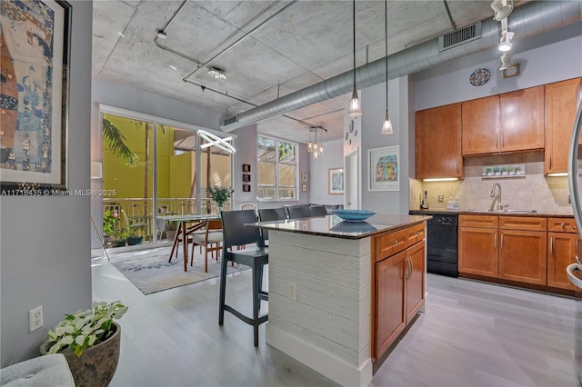 kitchen featuring sink, a center island, dishwasher, pendant lighting, and backsplash