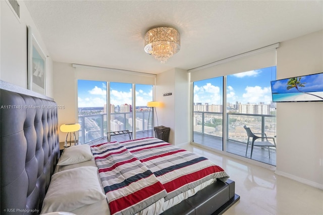 bedroom featuring access to exterior, a textured ceiling, expansive windows, and a notable chandelier