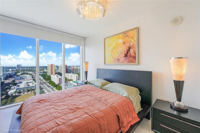 bedroom featuring a notable chandelier, a wall of windows, and access to outside