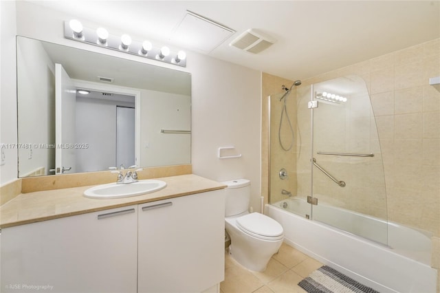 full bathroom featuring tile patterned flooring, vanity, tiled shower / bath combo, and toilet